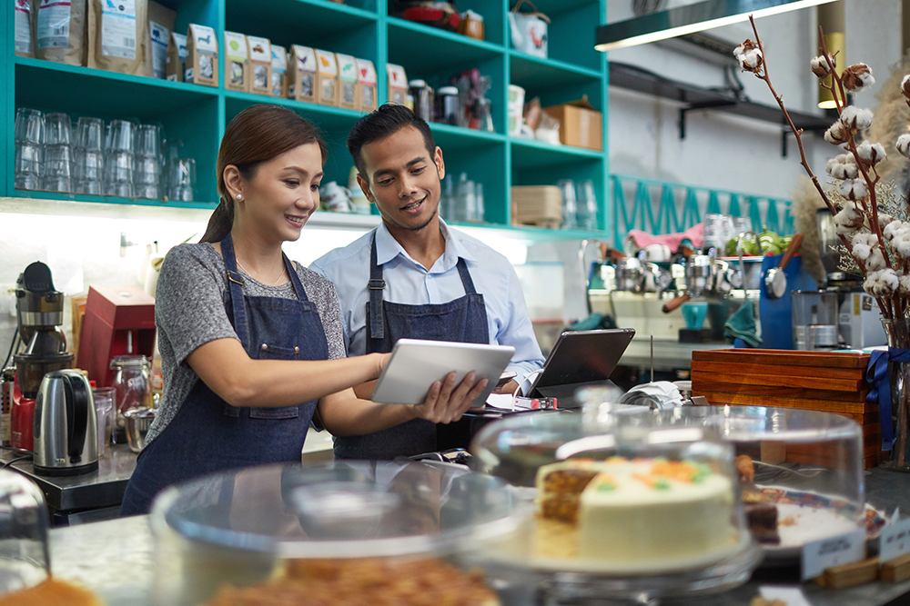 Restaurant owner and employee reviewing a document