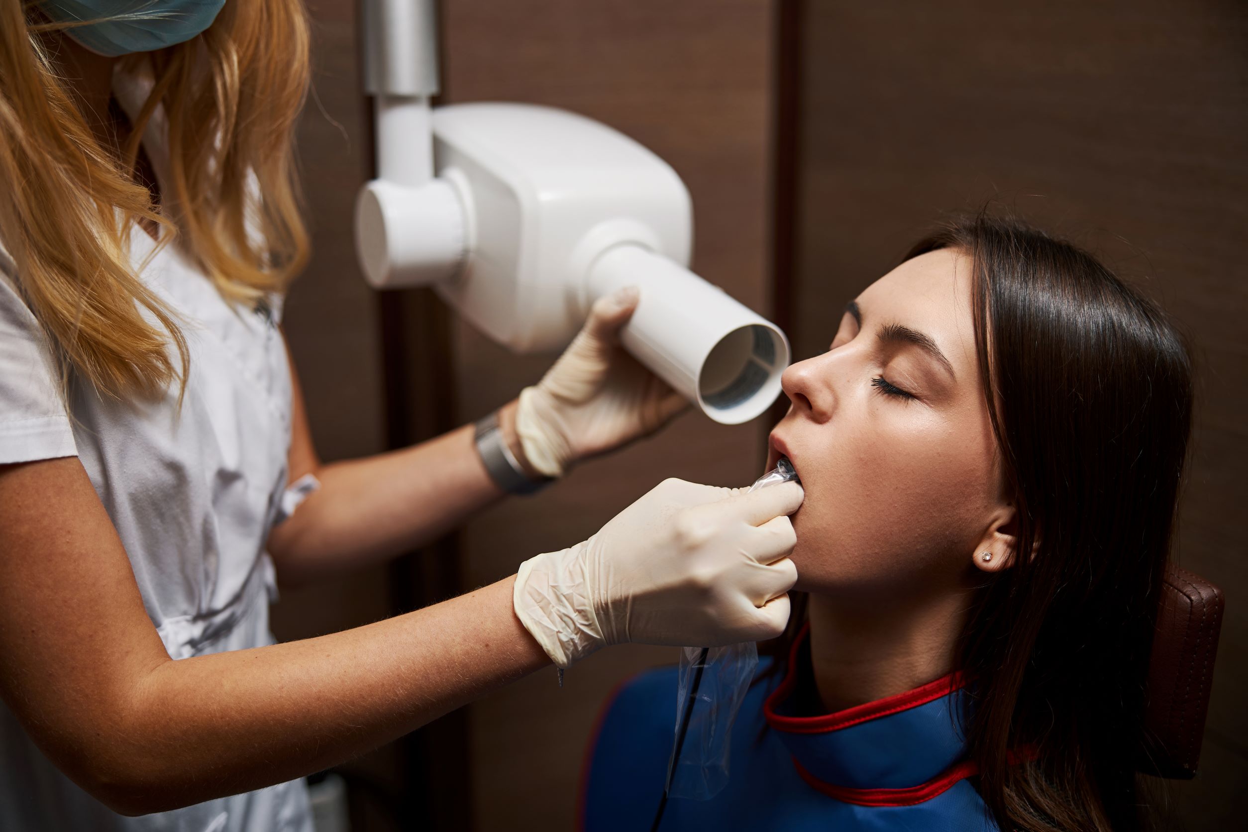 Dental patient is being fitted for dental X-rays