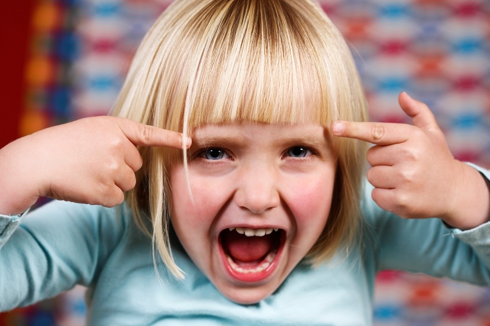 young girl looking agitated and pointing at eyes young girl looking agitated and pointing at eyes