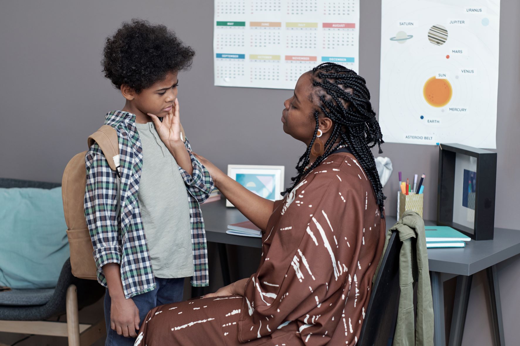 A teacher comforting an elementary school student with a toothache