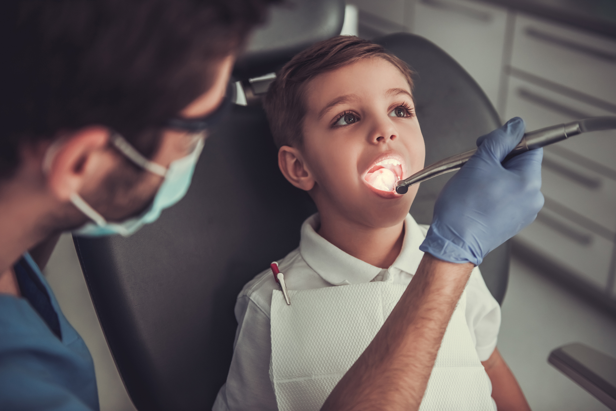 Dentist examines young boy’s mouth