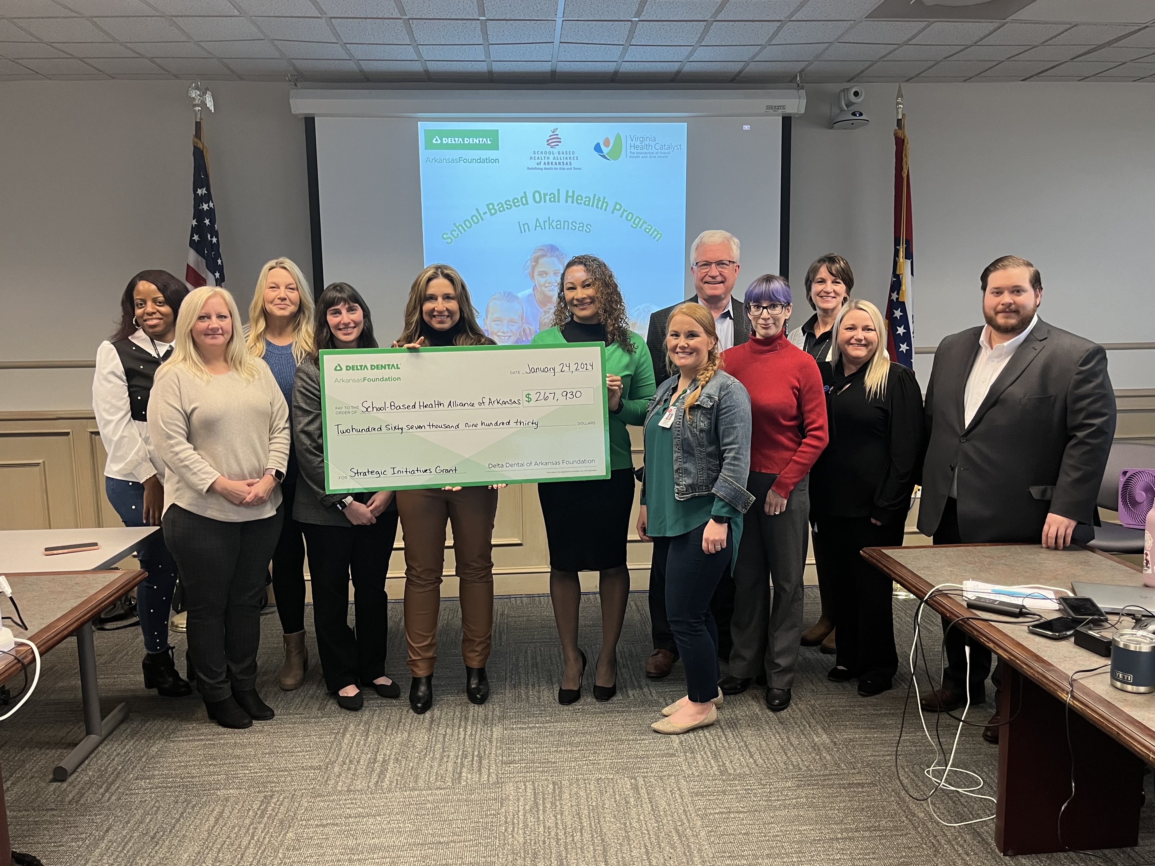 Sharon Lanier, Ph.D., executive director of the Delta Dental of Arkansas Foundation, center, presents a $267,930 check to Tamara Baker, RN, MPH, executive director of the School-Based Health Alliance of Arkansas, to her left, on January 24, 2024.