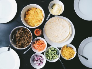Build-your-own taco bar with tortillas, cheese, beans, peppers, onions and other toppings